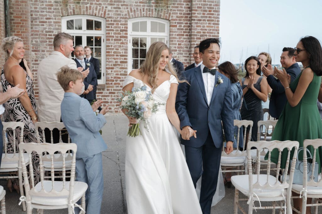 A bride and groom smile as they walk down the aisle during their wedding in san antonio texas