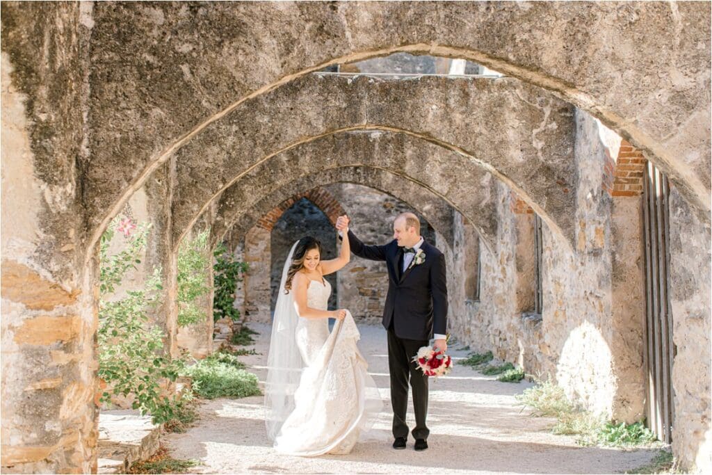 A bride and groom pose for their wedding day photos at Mission San Jose in San Antonio, Texas